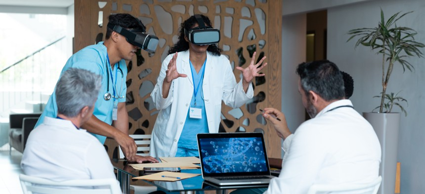 Photo of researchers using goggles associated with augmented and virtual reality technology. WAVEBREAKMEDIA/GETTY IMAGES