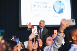 CUGH attendees storm the stage to take selfies with special guest Dr. Anthony Fauci. (Photo: CUGH)