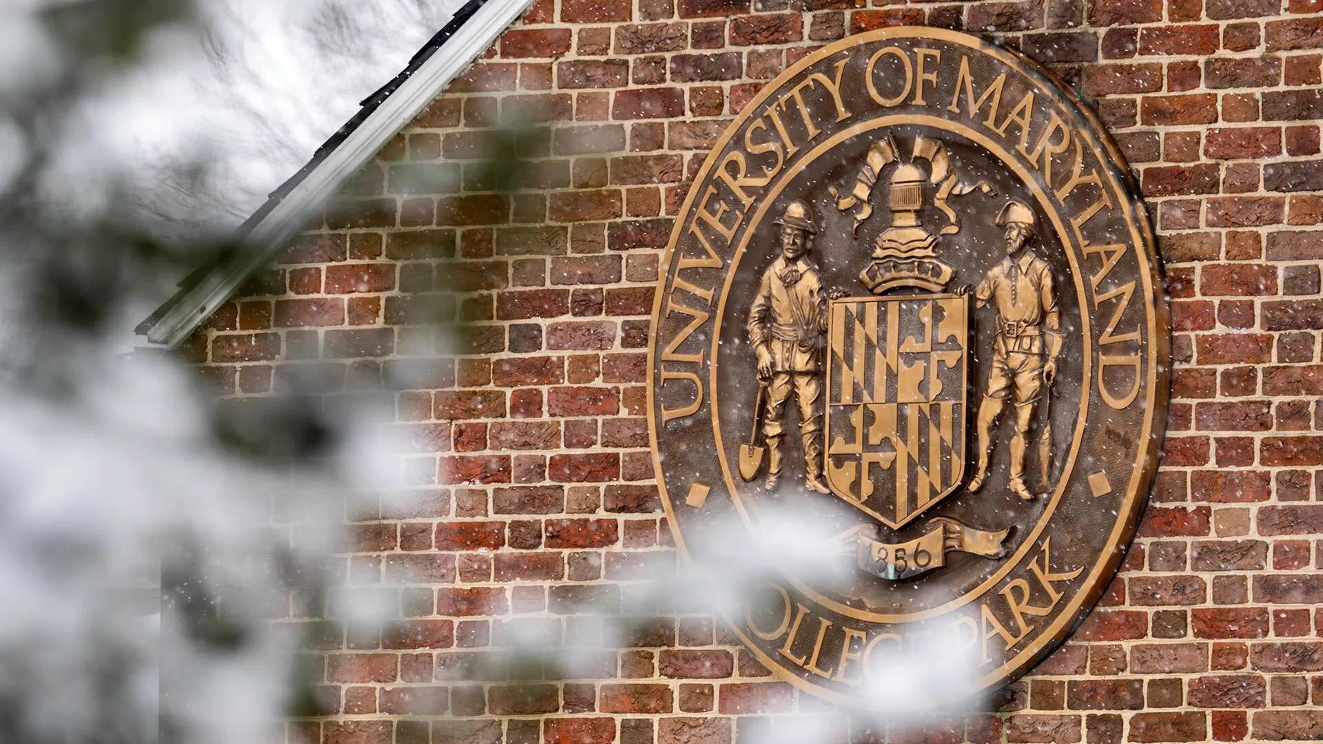 Campus_Snow_03022026_SC_0437_1920x1080 An image of the UMCP seal on a brick wall